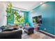 Cozy living room featuring vibrant blue walls, plush seating, and an abundance of natural light from a large window at 19802 E 54Th Ave, Denver, CO 80249