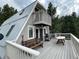 A-frame home with deck featuring a grill, table, and bench, offering scenic views at 4375 Tongue Rd, Indian Hills, CO 80454