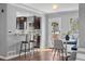 Open dining area with barstool seating, a marble table with white chairs, and a view of the kitchen at 4916 Knox Ct, Denver, CO 80221