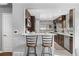 Bright kitchen featuring dark cabinetry, stainless steel appliances, and a breakfast bar at 4916 Knox Ct, Denver, CO 80221