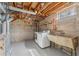 Unfinished laundry room featuring washer, dryer, utility sink, and open ceiling at 4916 Knox Ct, Denver, CO 80221
