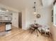 Bright dining room features wood floors and a modern light fixture over the table at 5467 Zephyr Ct # 5467, Arvada, CO 80002