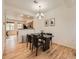 Dining area featuring a modern black table, dark chairs, stylish light fixture and open view to the kitchen at 5467 Zephyr Ct # 5467, Arvada, CO 80002