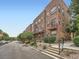 Attractive brick townhome showcasing balconies and professional landscaping with manicured shrubs along the walkway at 5467 Zephyr Ct # 5467, Arvada, CO 80002