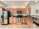 Bright kitchen with light wood cabinets, stainless steel appliances, and stylish hardwood floors at 5467 Zephyr Ct # 5467, Arvada, CO 80002
