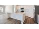 Modern kitchen with white cabinets, stainless steel appliances, a large island, and hardwood floors at 15286 Fillmore St, Thornton, CO 80602