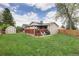 Large backyard with a green lawn, a storage shed, and a covered patio with seating at 6141 S Estes St, Littleton, CO 80123
