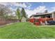 Spacious backyard featuring a well-maintained lawn, a storage shed, and a covered patio area at 6141 S Estes St, Littleton, CO 80123