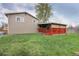 Expansive backyard featuring a well-maintained lawn, covered patio, and the home's exterior at 6141 S Estes St, Littleton, CO 80123