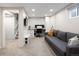 Finished basement with modern decor including a desk, couch, TV, and ample lighting at 6141 S Estes St, Littleton, CO 80123