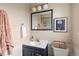 Classic bathroom with navy wainscoting, modern fixtures, and a framed flower art piece at 6141 S Estes St, Littleton, CO 80123