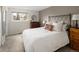 A sun-lit bedroom with carpet, a comfortable bed, two dressers, and a large window at 6141 S Estes St, Littleton, CO 80123