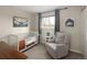 Cozy Bedroom with a crib, comfortable armchair, and mountain-themed artwork at 6141 S Estes St, Littleton, CO 80123