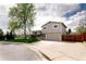 Inviting home exterior with a large driveway, tidy lawn, and mature trees at 6141 S Estes St, Littleton, CO 80123
