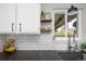 Bright kitchen featuring sleek countertops, floating shelves, and white subway tile at 6141 S Estes St, Littleton, CO 80123