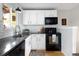 Charming kitchen with white cabinets, subway tile backsplash, and modern black appliances at 6141 S Estes St, Littleton, CO 80123