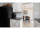Kitchen featuring white cabinets, subway tile backsplash, and a view of the dining room at 6141 S Estes St, Littleton, CO 80123