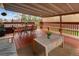 Charming covered patio with a red wood deck, comfortable seating and a dining area at 6141 S Estes St, Littleton, CO 80123