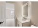 Well-lit bathroom featuring a contemporary vanity with an illuminated mirror and a view into an adjacent bedroom with neutral carpeting at 15870 Duckweed Ct, Parker, CO 80134