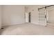 Bright bedroom with modern barn door and neutral carpet at 15870 Duckweed Ct, Parker, CO 80134