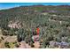 An aerial view of a mountain home surrounded by trees at 8171 S Homesteader Dr, Morrison, CO 80465