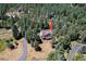 An aerial view of a mountain home surrounded by dense green trees at 8171 S Homesteader Dr, Morrison, CO 80465