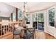 Bright dining area featuring a glass table, wood floors, and access to the deck with wooded views at 8171 S Homesteader Dr, Morrison, CO 80465