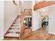 Open foyer featuring a wooden staircase, hardwood floors, and a view into the living spaces at 8171 S Homesteader Dr, Morrison, CO 80465