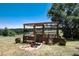 View of the wooden raised garden bed, featuring an iron gate, planters, and a surrounding landscape at 8171 S Homesteader Dr, Morrison, CO 80465