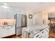 Spacious kitchen featuring white cabinets, stainless steel refrigerator, and a granite island at 8171 S Homesteader Dr, Morrison, CO 80465