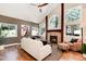 Cozy living room with vaulted ceiling, fireplace, and large windows offering natural light and wooded views at 8171 S Homesteader Dr, Morrison, CO 80465