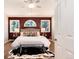 Bedroom featuring a king bed, wood floors, and an accent wall with charming windows at 8171 S Homesteader Dr, Morrison, CO 80465