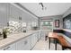 Modern kitchen featuring white cabinets, tiled backsplash, and a cozy breakfast nook at 7201 E Quincy Ave # 102, Denver, CO 80237