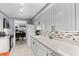 Well-lit kitchen with white cabinets, tiled backsplash, and a view to the grand piano at 7201 E Quincy Ave # 102, Denver, CO 80237