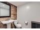 Bathroom featuring brick accents, a pedestal sink, and modern fixtures at 3138 N Josephine St, Denver, CO 80205