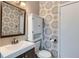 Bathroom with a modern vanity, decorative wallpaper, and white cabinet above the toilet at 3138 N Josephine St, Denver, CO 80205