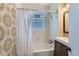 Bright bathroom featuring white tiled walls, tub with shower, decorative wallpaper, and modern vanity at 3138 N Josephine St, Denver, CO 80205