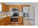 Bright kitchen features stainless steel appliances including a refrigerator and oven and oak cabinets at 19216 E Idaho Pl # 102, Aurora, CO 80017