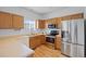 Bright kitchen features stainless steel appliances and oak cabinets with laminate countertops and wood-look flooring at 19216 E Idaho Pl # 102, Aurora, CO 80017