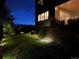 Backyard featuring lush green grass, mature trees and landscape lighting at 4526 Colorado River Dr, Firestone, CO 80504