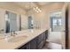 Modern bathroom with dual sinks, sleek vanity, and a view into the bedroom at 4526 Colorado River Dr, Firestone, CO 80504