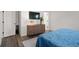 Cozy bedroom featuring a blue bedspread, light wood floors, and a modern dresser at 3061 Low Meadow Blvd, Castle Rock, CO 80109