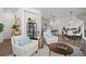 Open-concept living room with comfortable armchairs, view to modern kitchen at 3061 Low Meadow Blvd, Castle Rock, CO 80109