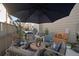 Entertaining patio with an umbrella, grill, dining area, and comfortable lounge furniture at 3061 Low Meadow Blvd, Castle Rock, CO 80109