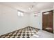 Basement room with windows, stained door, and checkered flooring at 10705 Downing St, Northglenn, CO 80233