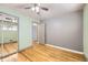 Bright bedroom featuring hardwood floors, ceiling fan, and a mirrored closet at 10705 Downing St, Northglenn, CO 80233