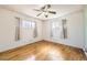 Bedroom featuring wood floors, two windows, neutral curtains and ceiling fan with light at 10705 Downing St, Northglenn, CO 80233