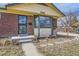 Close up shot of the brick home's front porch and yard featuring updated landscaping at 10705 Downing St, Northglenn, CO 80233