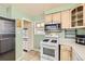 This kitchen features modern appliances and light-colored cabinets, with an adjacent doorway and plenty of sunlight at 10705 Downing St, Northglenn, CO 80233