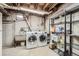 Functional laundry room with washer, dryer, utility sink, and wire shelving for organized storage at 10705 Downing St, Northglenn, CO 80233